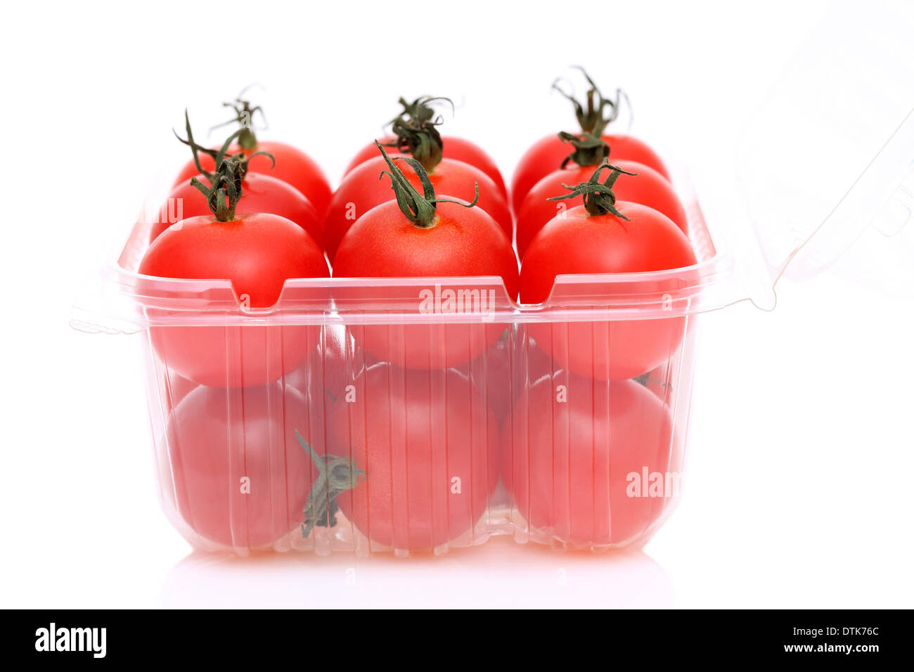 Tomates cherry en un recipiente de plástico Foto de stock