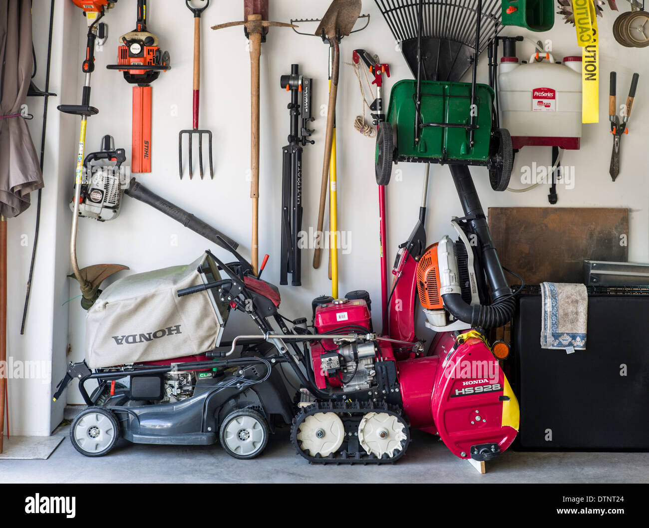 Las herramientas de jardín y equipo dentro del garaje residencial Foto de stock