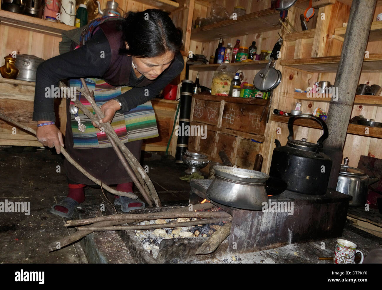 Mujer tibetana cocinar en una estufa de leña en el valle Tsum, Nepal. Foto de stock