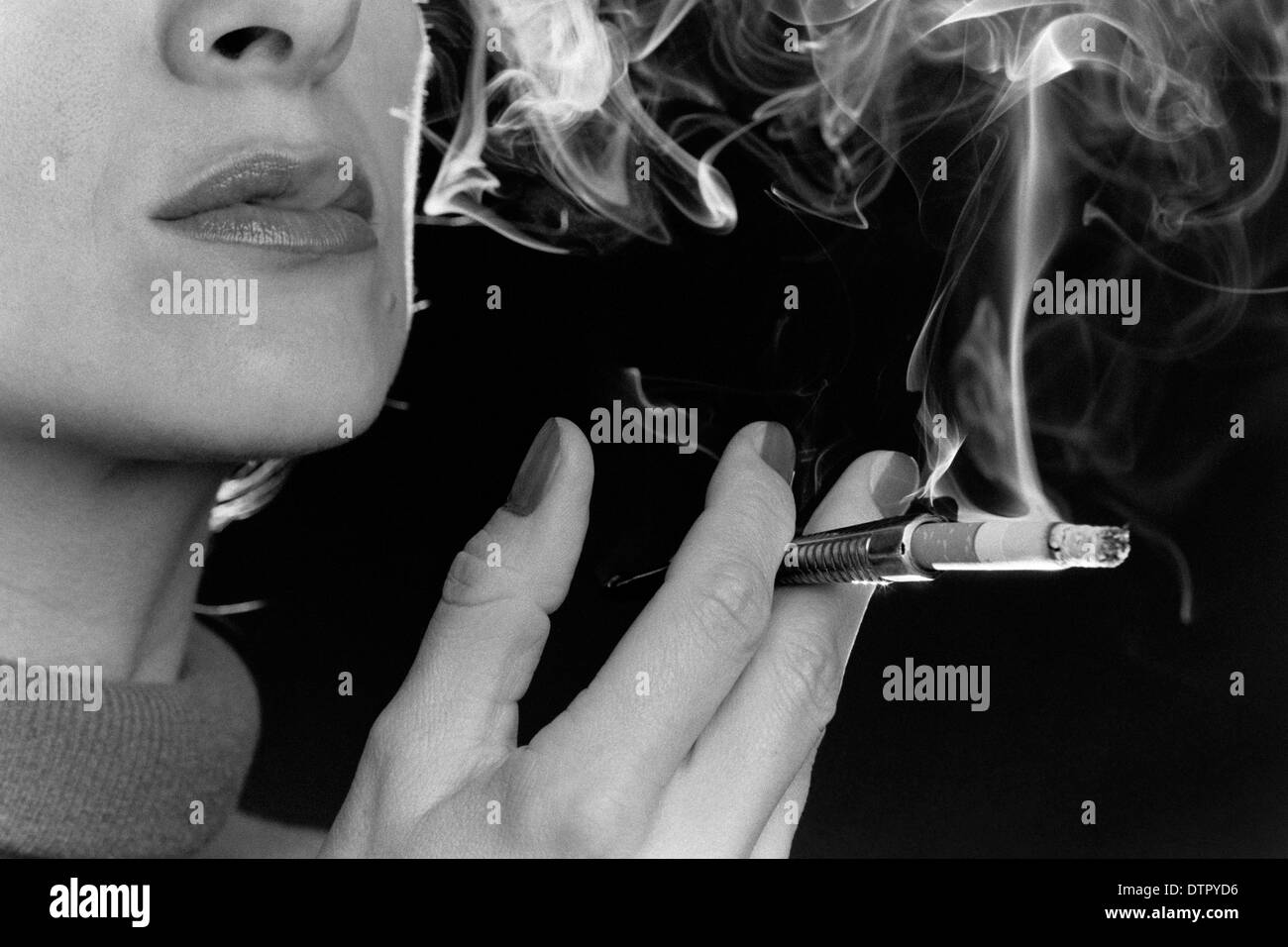Un primer plano de una mujer fumando un cigarrillo con un titular de cigarrillos Foto de stock