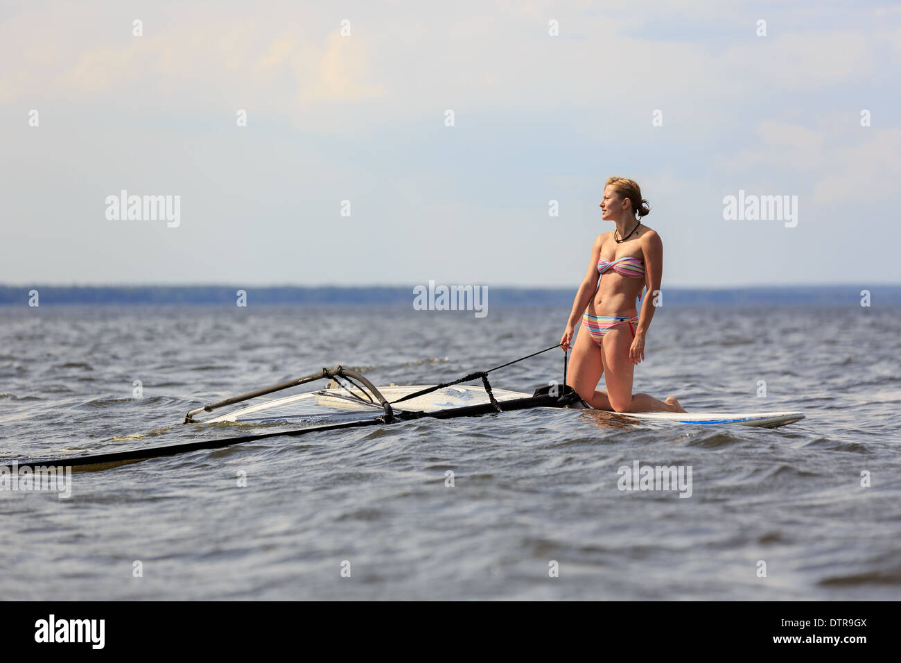 Feliz windsurfista tomar un descanso en la junta Foto de stock