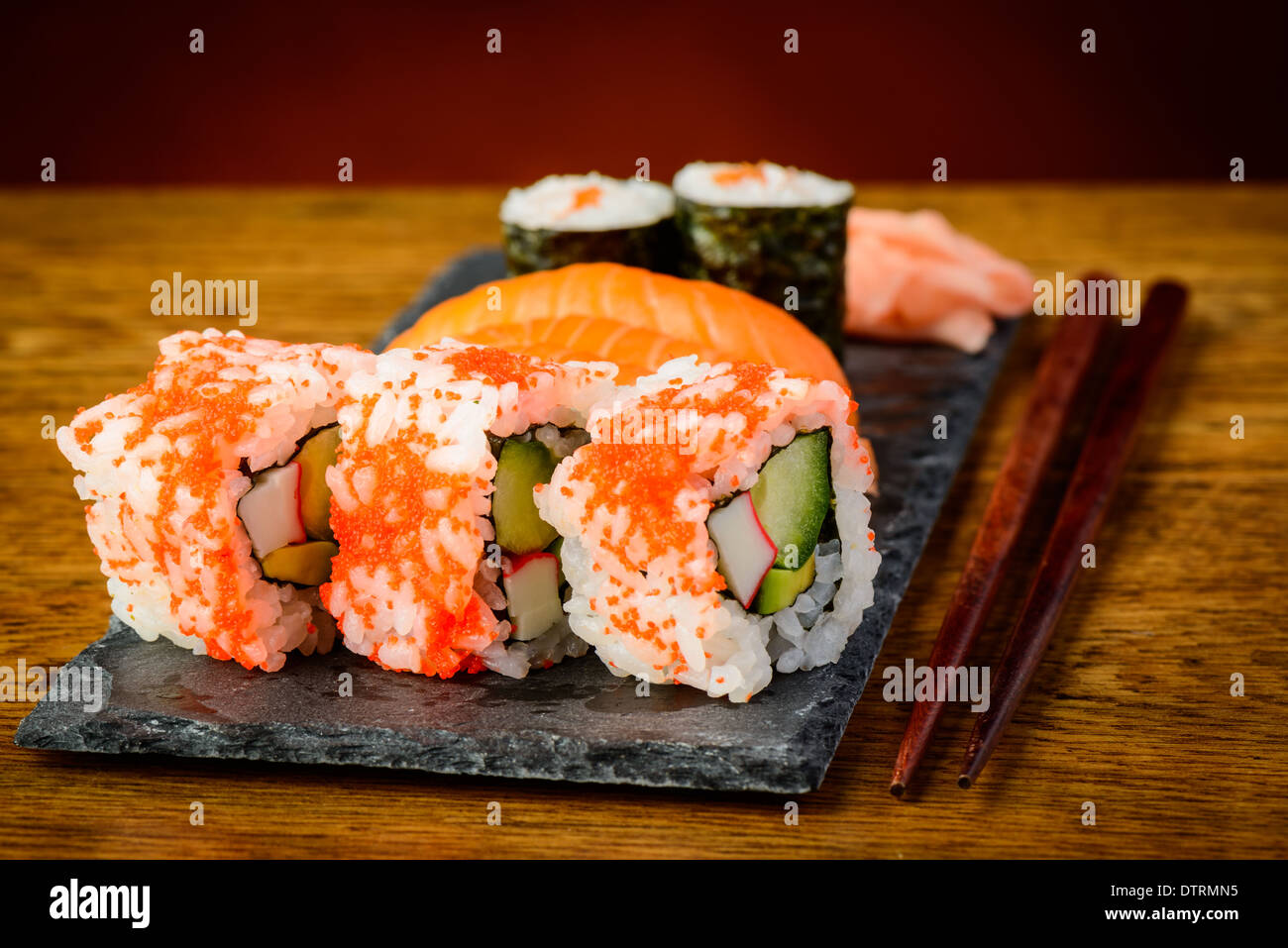Bodegón con palillos y placa de sushi mixto Foto de stock