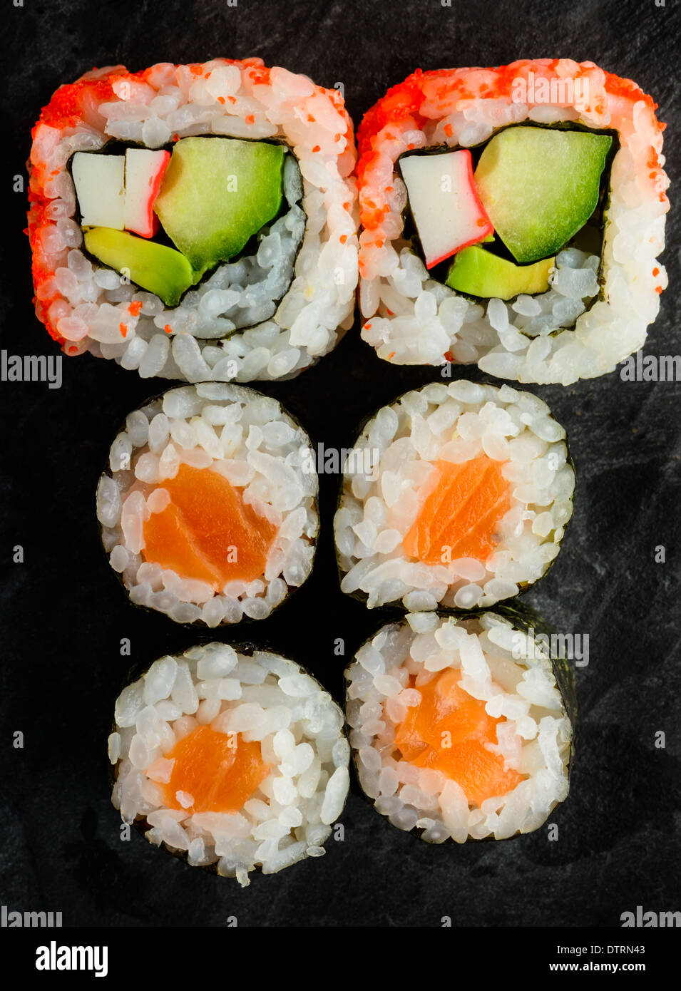 Placa con Maki Sushi mixto y California rolls uramaki Foto de stock