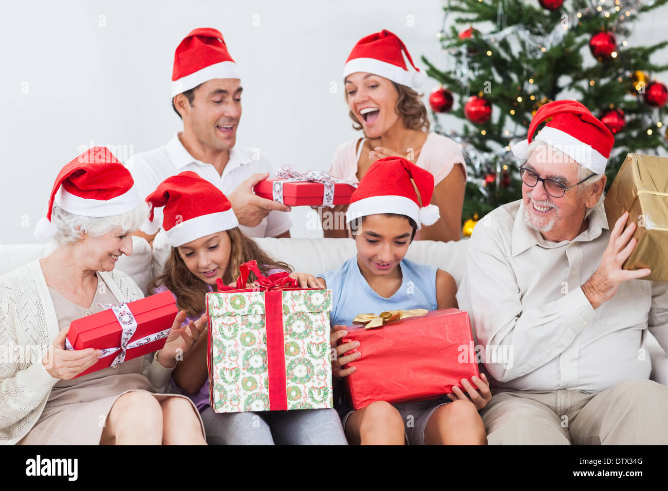 Emocionada familia intercambiando regalos en Navidad Foto de stock