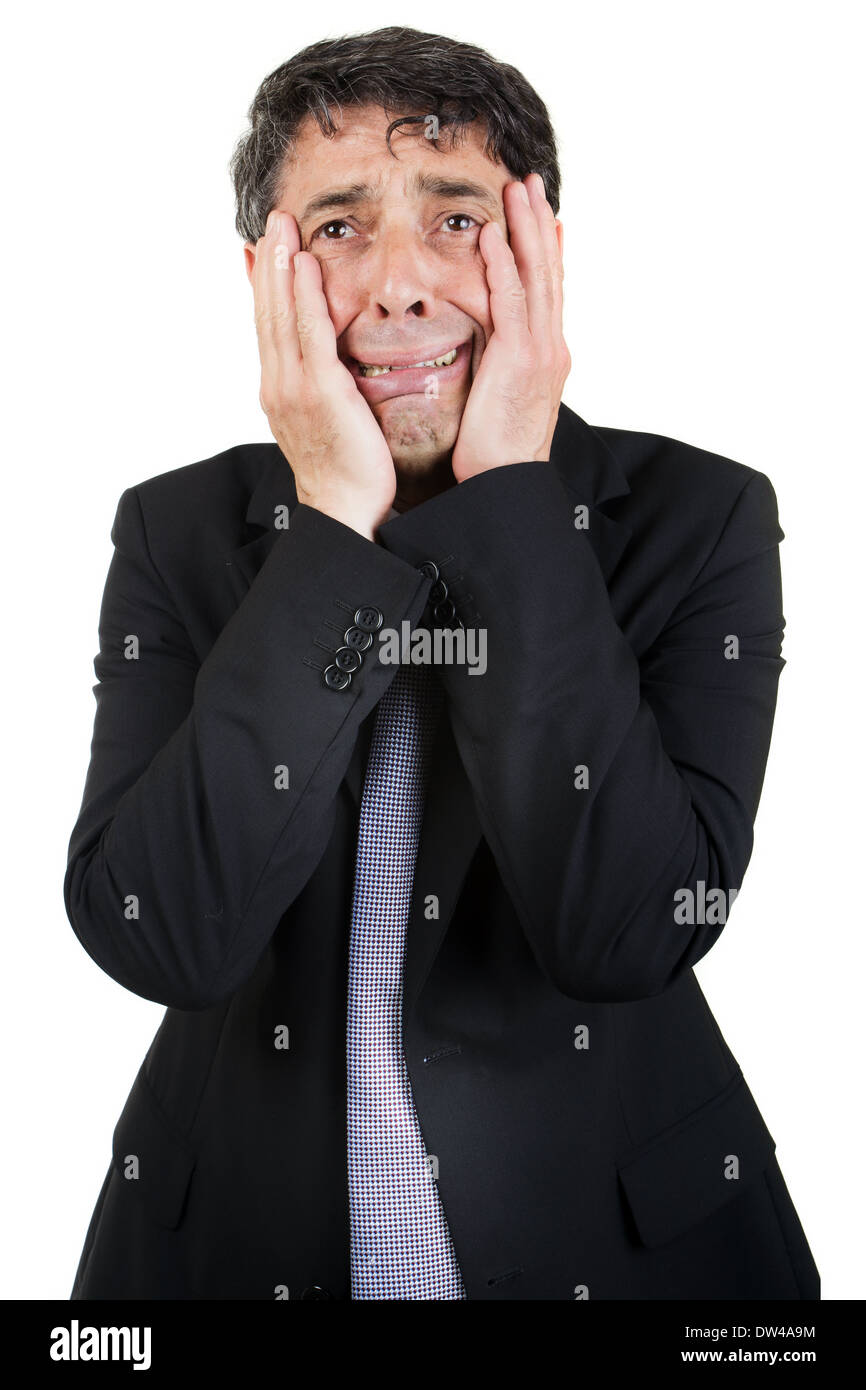 Empresario Griefstricken sosteniendo su rostro en sus manos como llora a sí mismo con una expresión woebegone, aislado en blanco Foto de stock