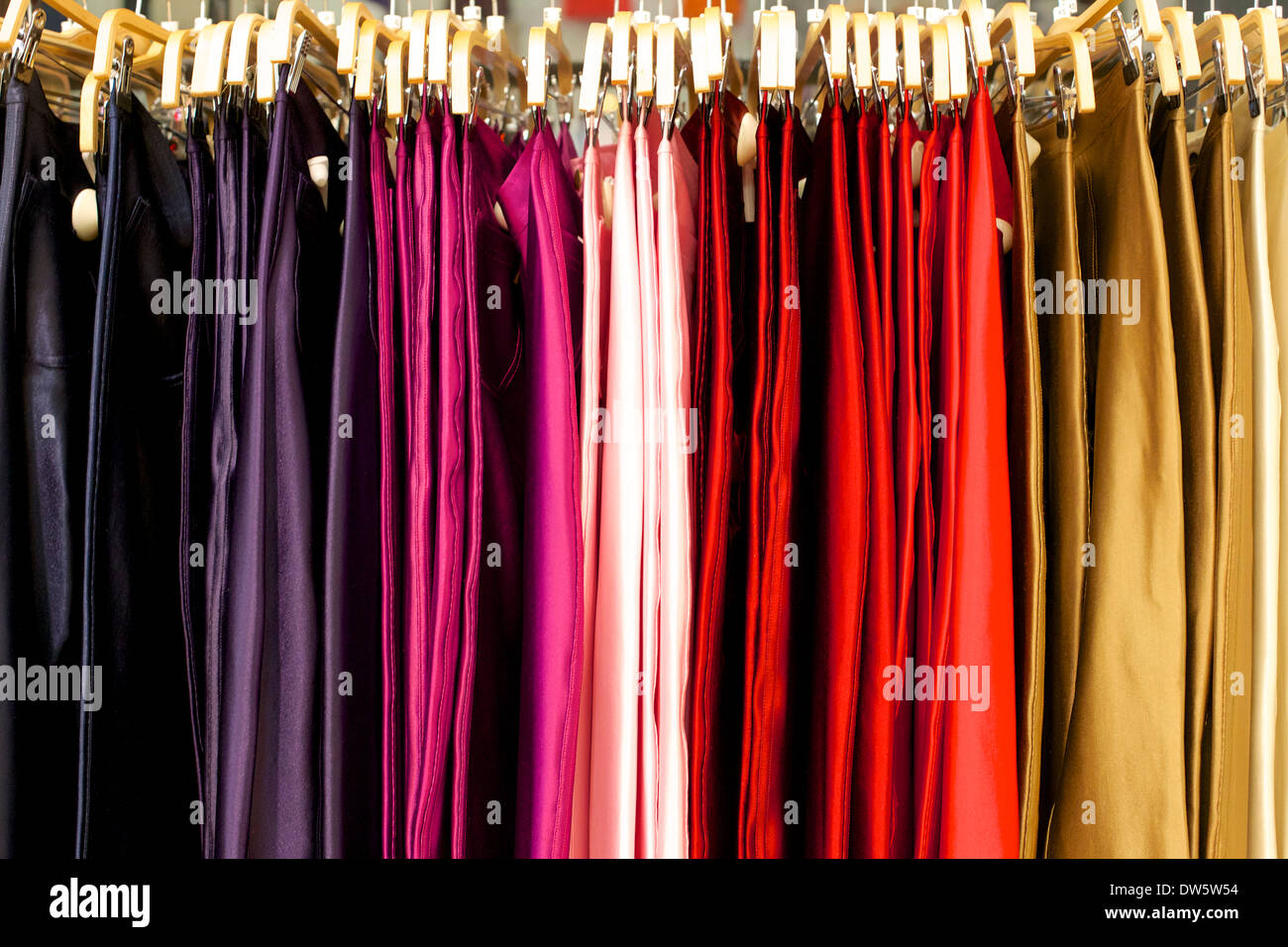 Faldas en muchos colores colgando de un perchero en una tienda de ropa. Foto de stock