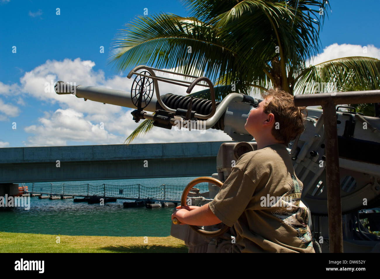 Chico mirando Anti-Aircraft guns, Pearl Harbor, Oahu, Hawaii Foto de stock