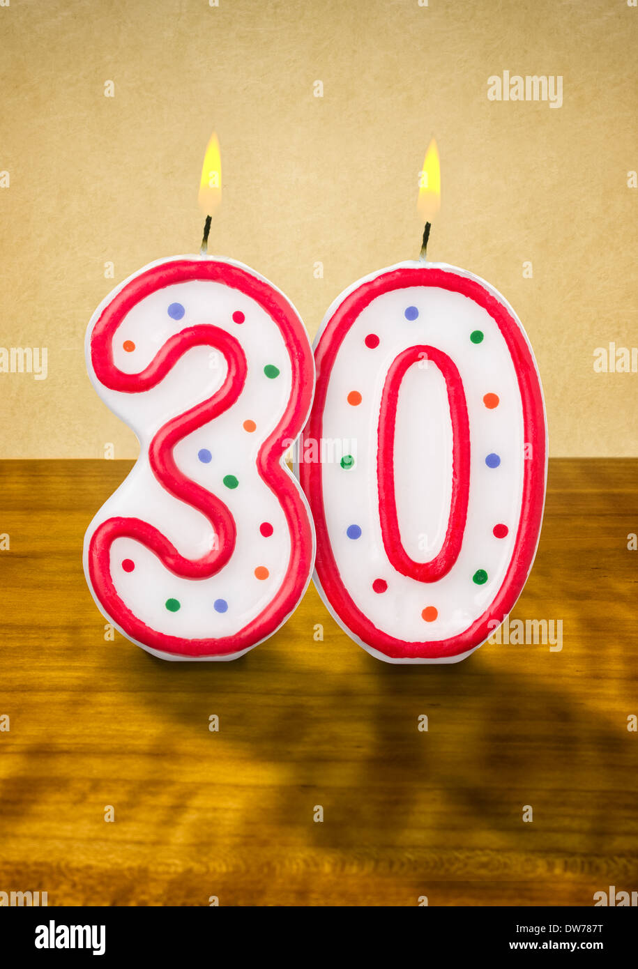 Quemando velas de cumpleaños número 30 Fotografía de stock - Alamy