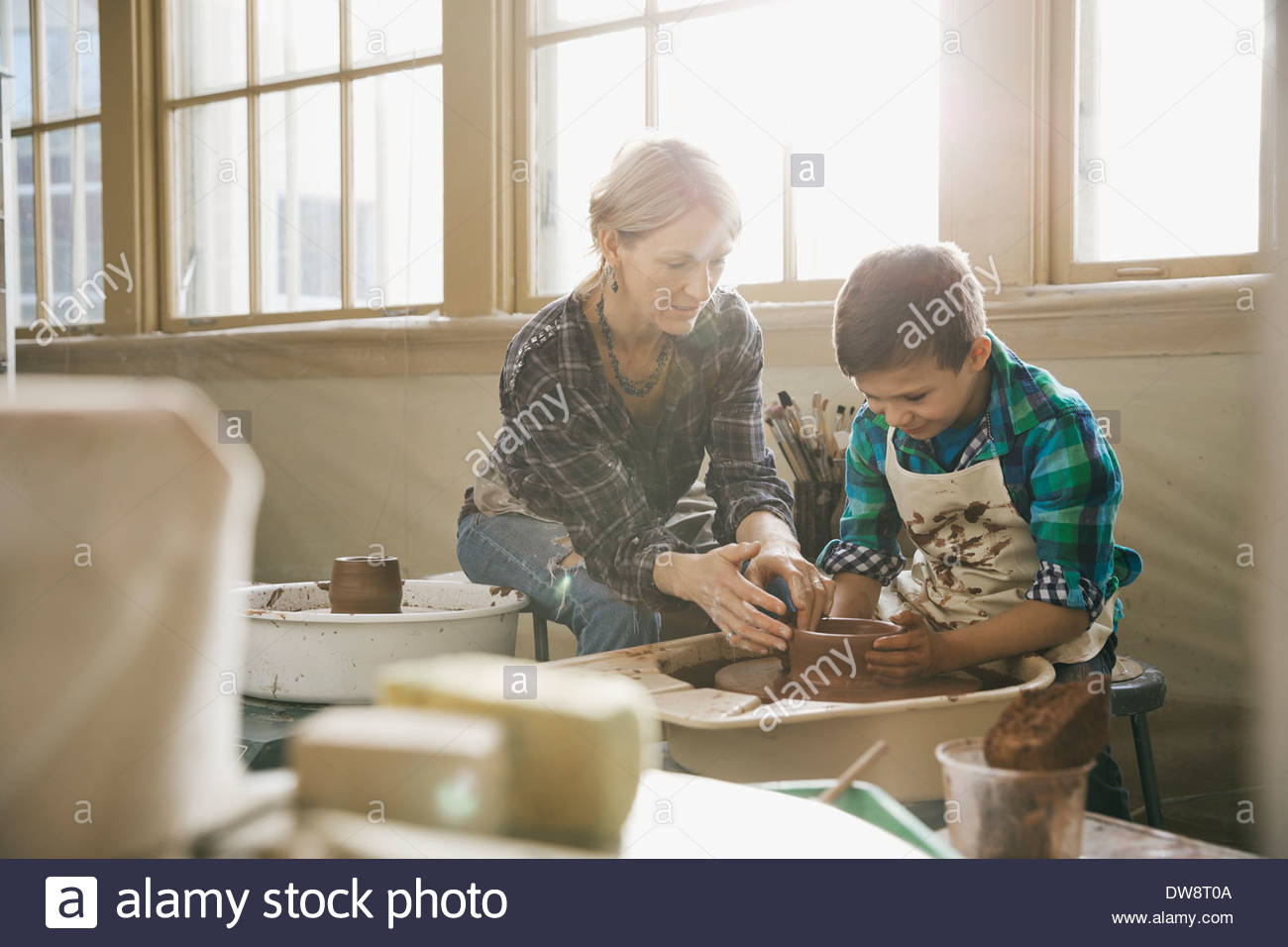 Profesora ayudando a niño en clases de alfarería Foto de stock