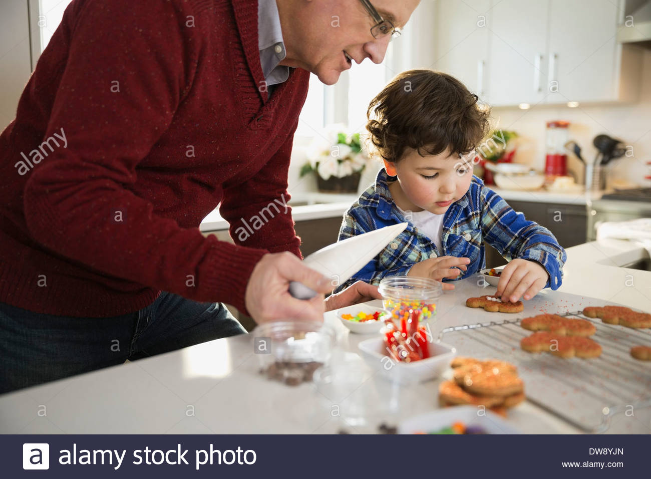 Abuelo y nieto decorar galletas de Navidad juntos Foto de stock