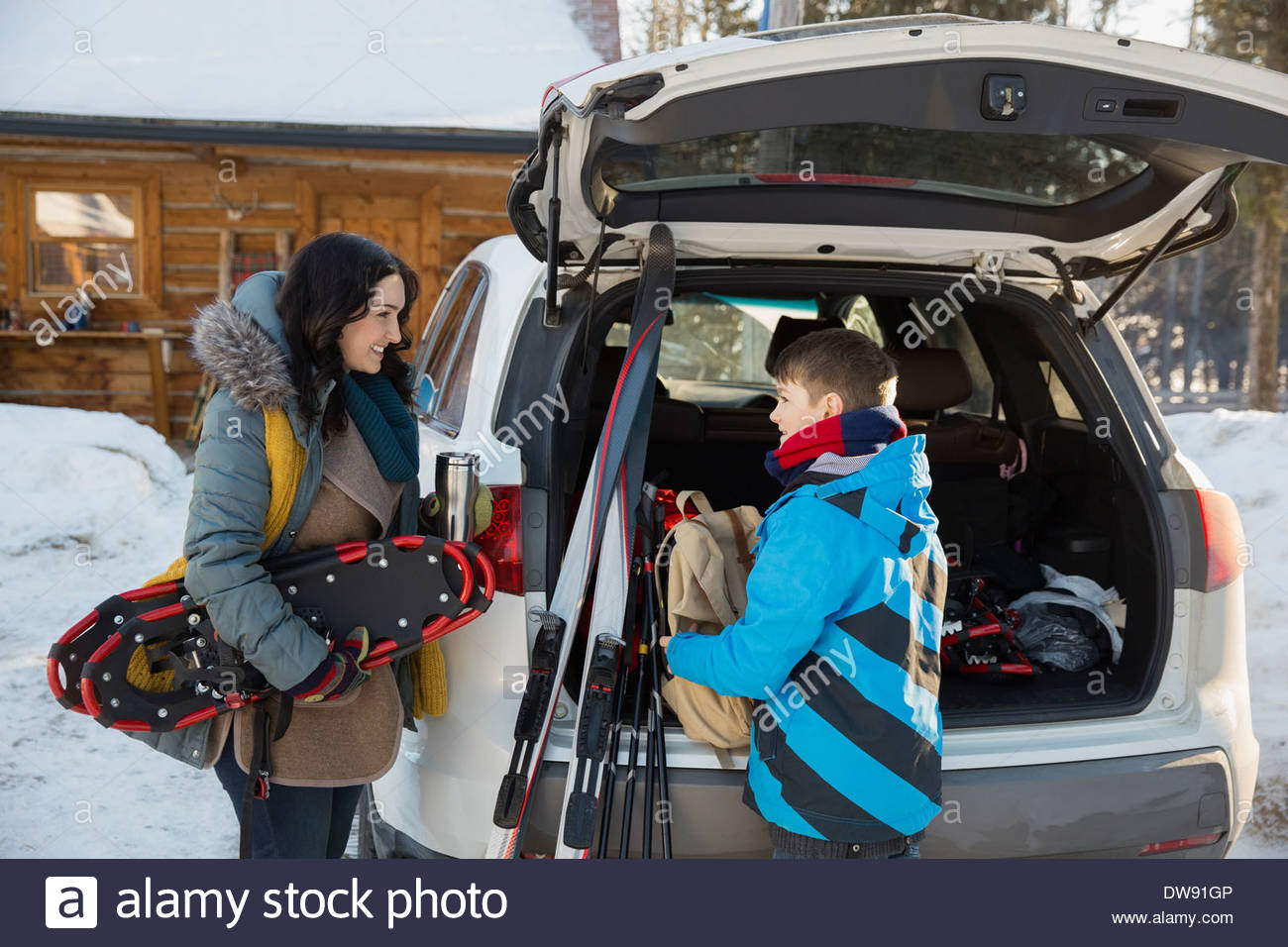 Madre e hijo descarga el engranaje del coche de deportes de invierno Foto de stock