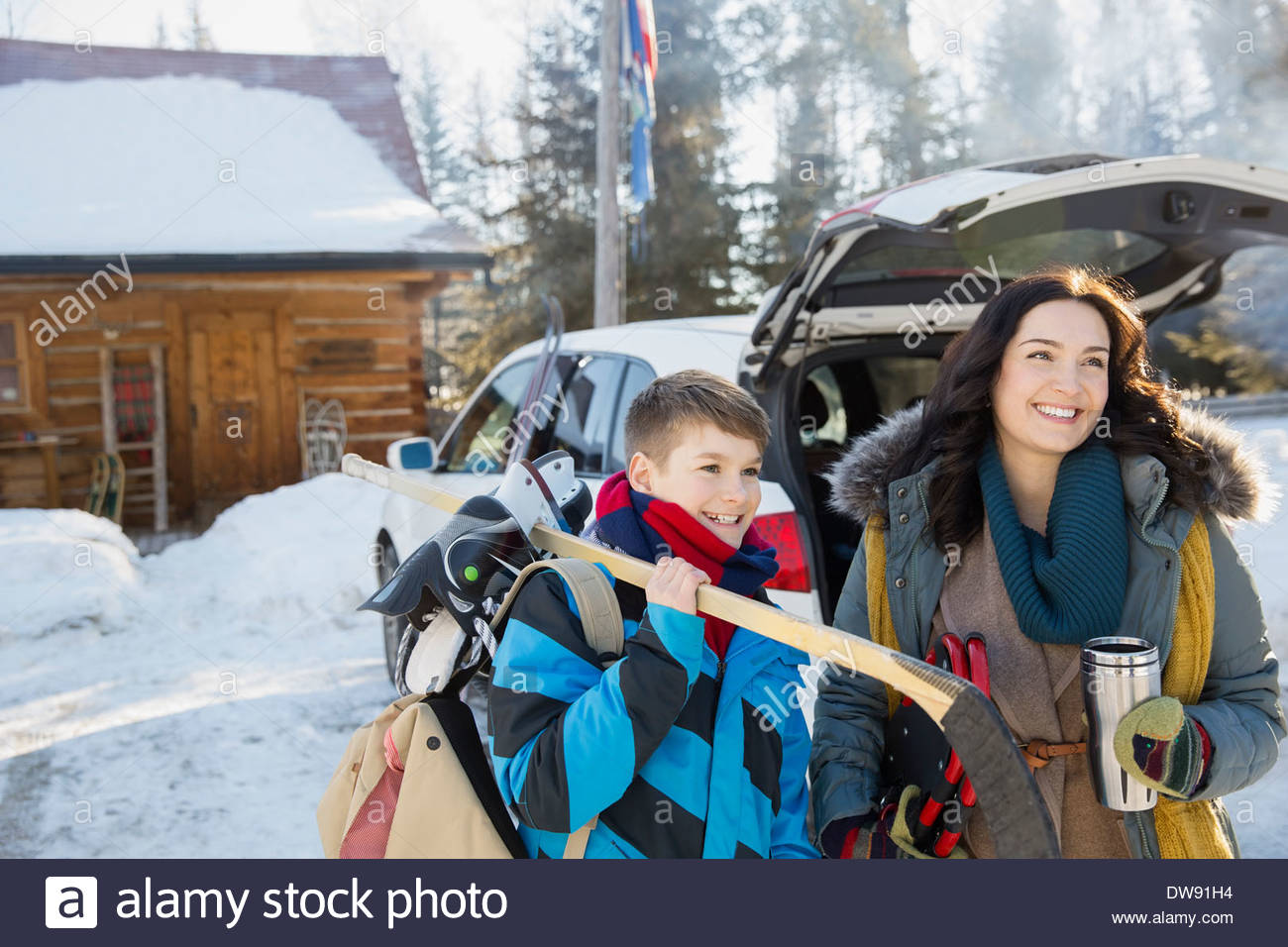 Madre e hijo de pie al aire libre con el engranaje de los deportes de invierno Foto de stock
