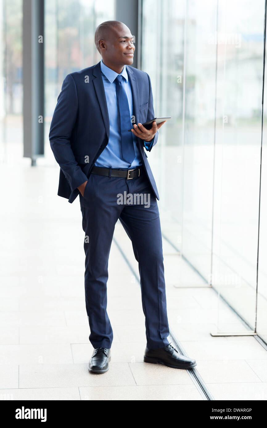 Pensativo empresario africano con tablet PC en la oficina Foto de stock
