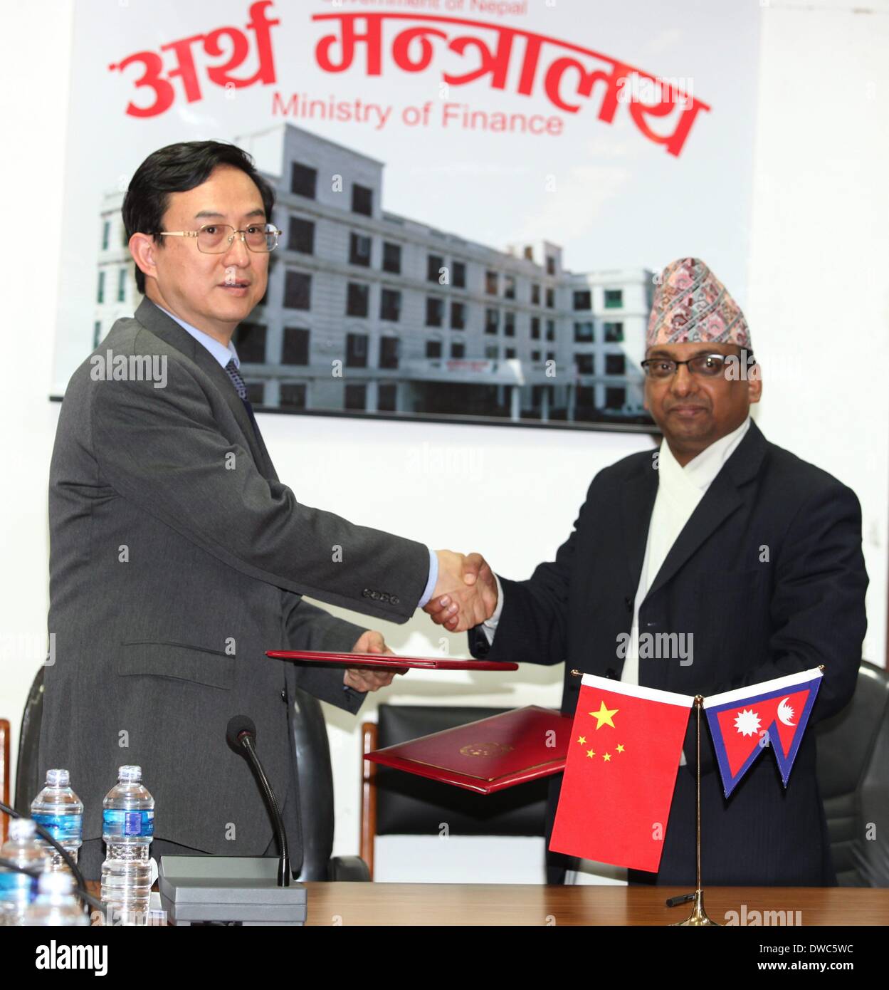 Katmandú, Nepal. 5 Mar, 2014. El embajador chino en Nepal Wu Chuntai (L) y el Secretario de Hacienda de Nepal Shanta Raj Subedre agitar las manos después de la ceremonia de firma del acuerdo de concesión de ayuda paquete a Nepal en el Ministerio de Finanzas en Katmandú, Nepal, 5 de marzo de 2014. El gobierno chino el miércoles acordó conceder una asistencia paquete valorado en 1,92 billones de rupias nepalesas (19,2 millones de dólares EE.UU.) a Nepal. Funcionarios del Ministerio de Hacienda de Nepal dijo que la asistencia fue proporcionada para financiar proyectos de cooperación económica y técnica entre los dos países. Crédito: Sunil Sharma/Xinhua/Alamy vivir ne Foto de stock