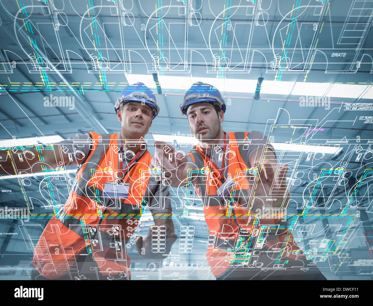 Constructores mirando los planes a través de una pantalla interactiva Foto de stock