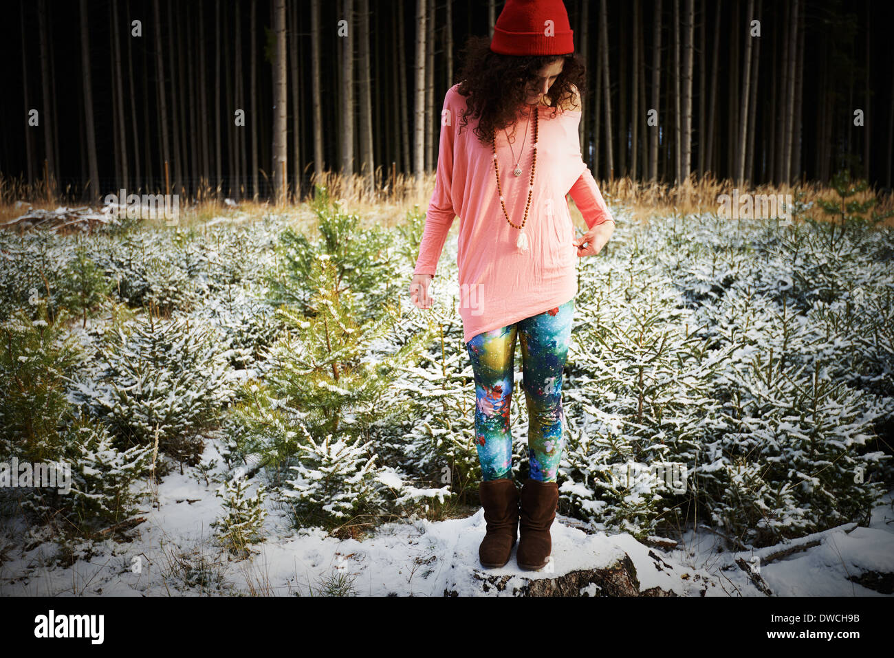 Mitad mujer adulta en hat, de pie en el suelo cubierto de nieve Foto de stock
