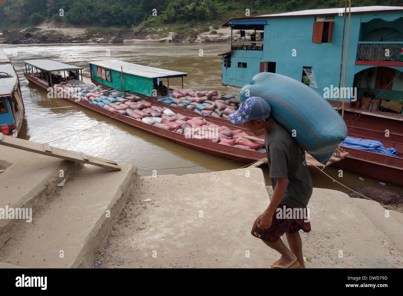 Los trabajadores con pesados sacos de selva, producto de un cargamento en  barco por el río Mekong, Pakbeng, Laos Fotografía de stock - Alamy