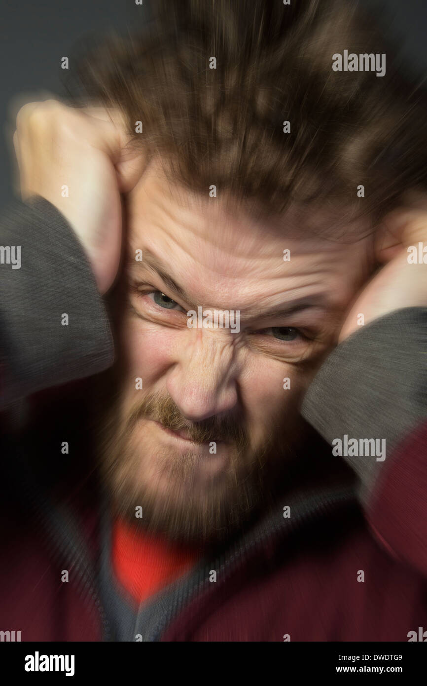 Un hombre enojado rompe su cabello Foto de stock