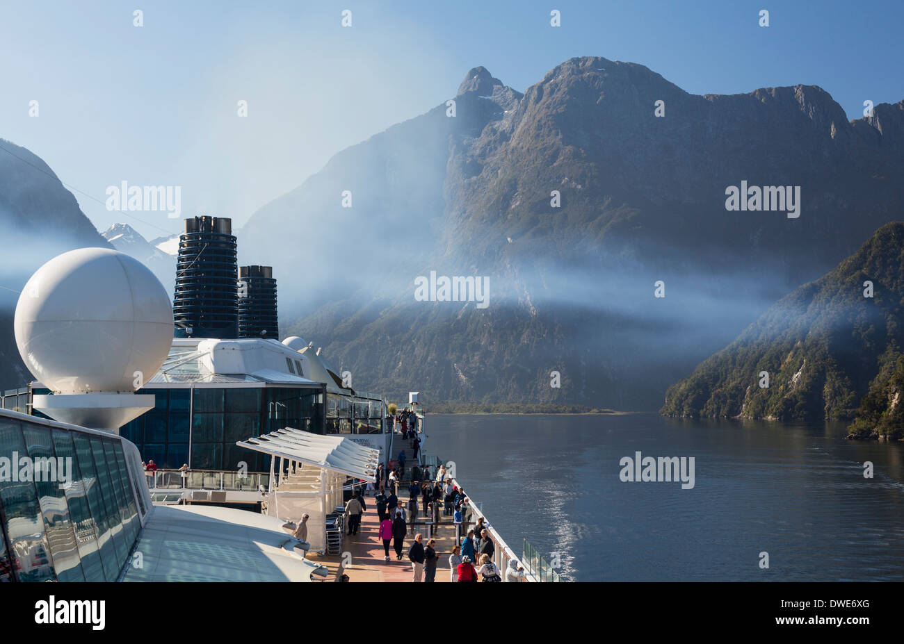 Milford Sound en el Parque Nacional Fiordland - Pasajeros en crucero que navegaba hacia Milford Sound, Isla del Sur, Nueva Zelanda, temprano en la mañana Foto de stock