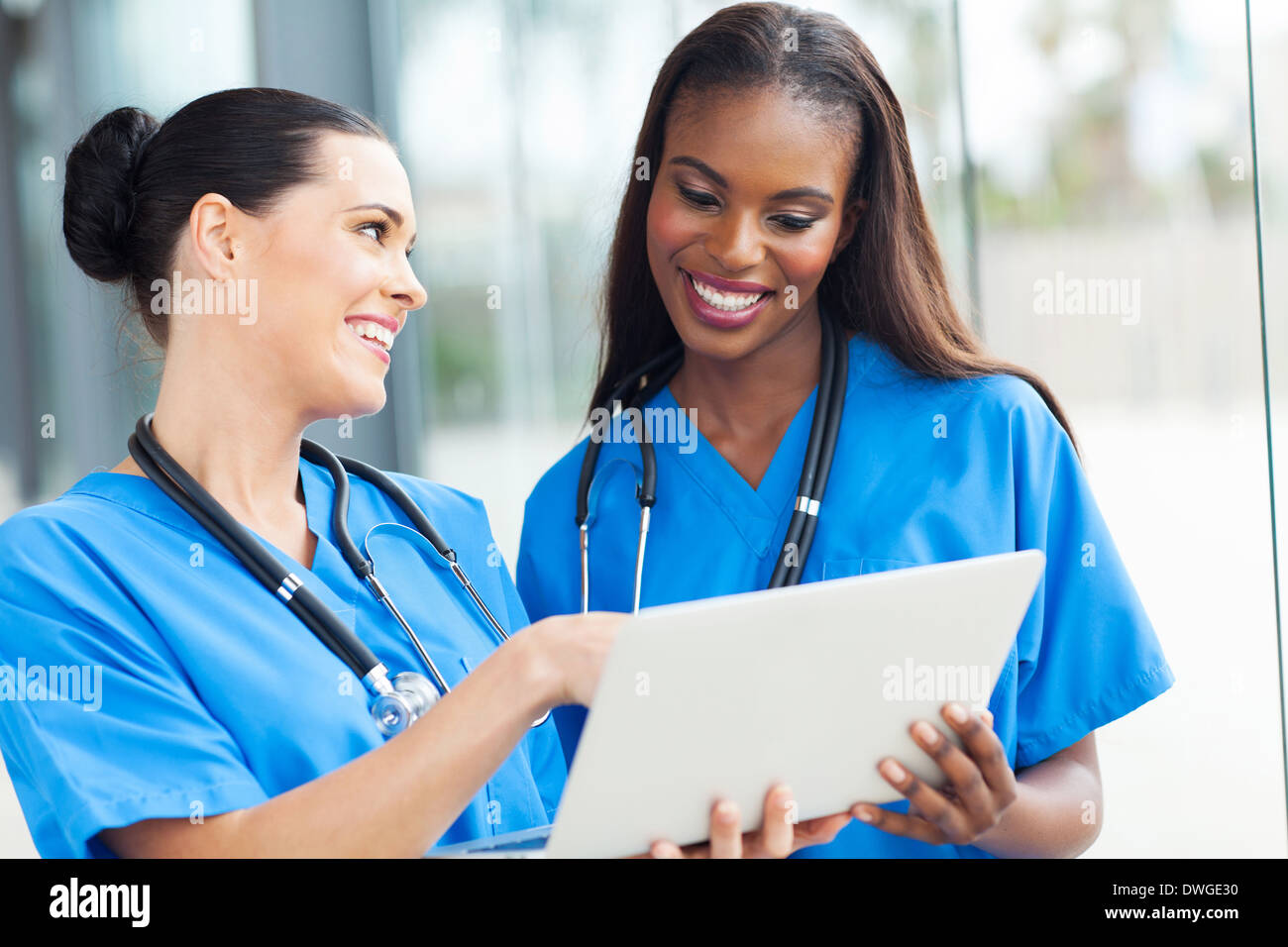 Dos bonitas enfermeras utilizando equipo portátil Foto de stock