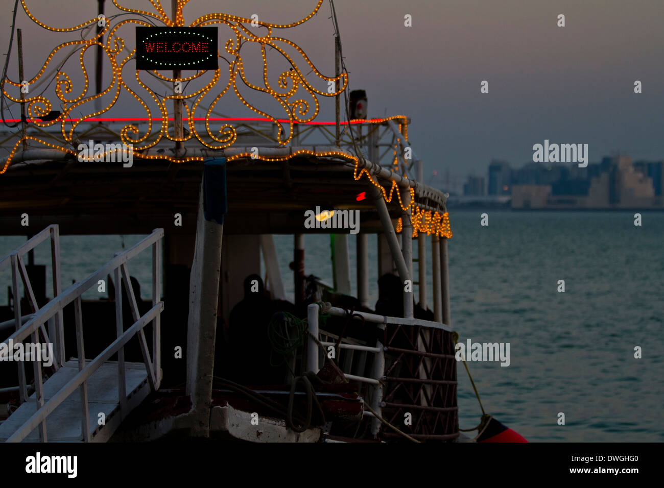 Qatar Doha las luces de la ciudad frente al mar embarcaciones tradicionales Foto de stock