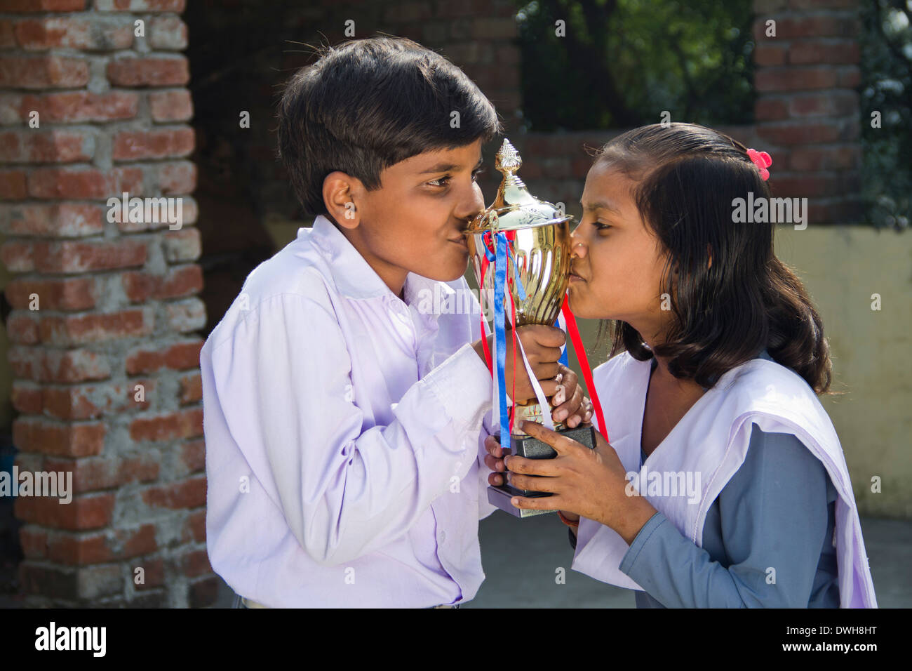 Los niños rurales indios de pie con el trofeo en casa Foto de stock