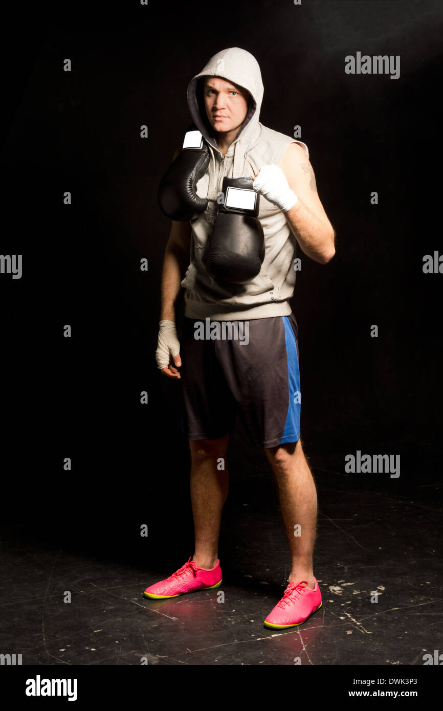 Determina guapo joven boxeador esperando para su lucha con sus guantes  colgando alrededor de su cuello y sus manos vendadas Fotografía de stock -  Alamy