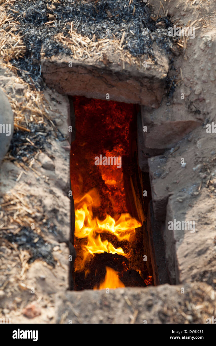 Rajasthan, India. Rejilla de ventilación en el horno de ladrillo subterráneo revela el fuego interior. Foto de stock