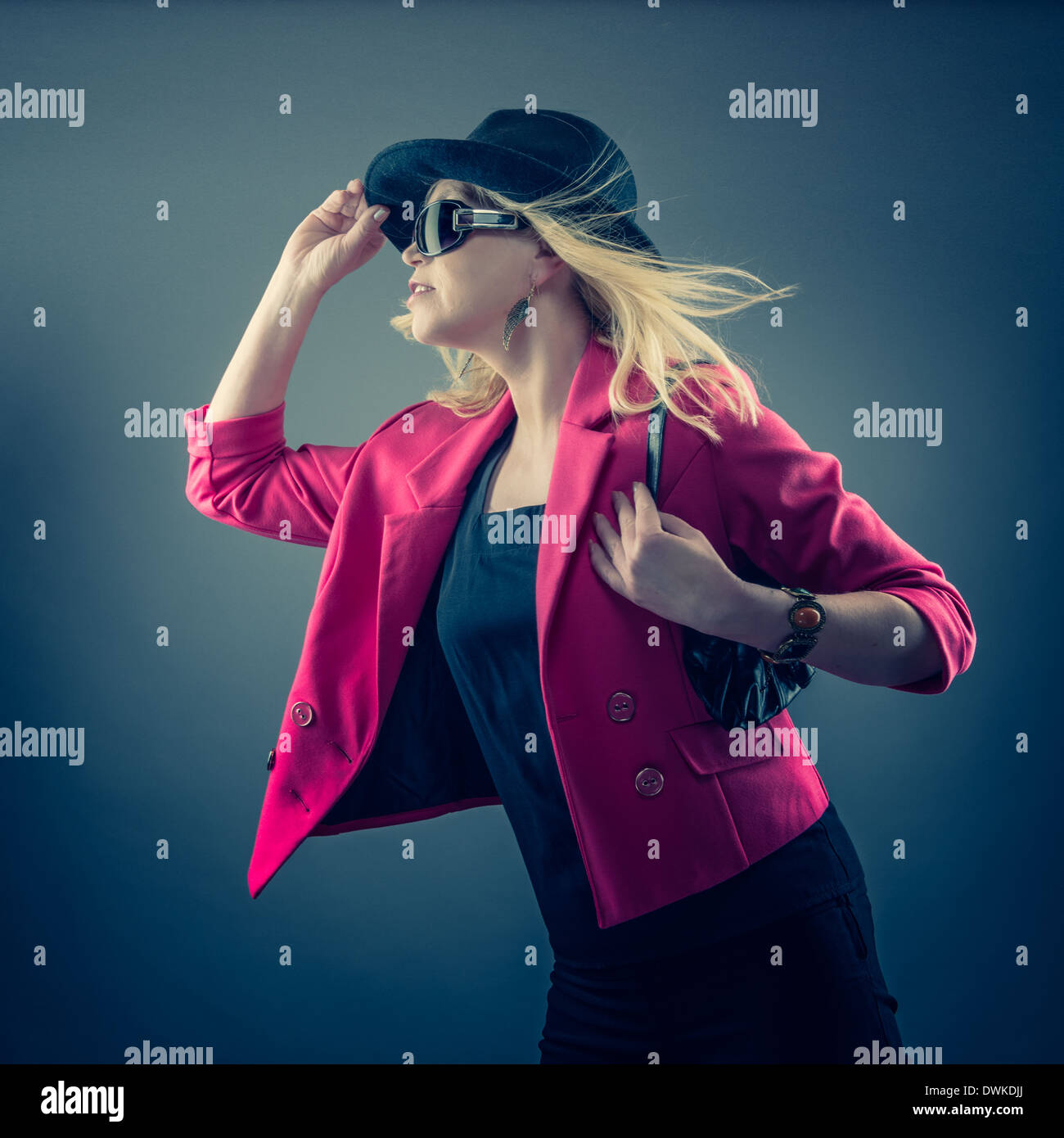 Urbane mujer madura, vistiendo un sombrero, gafas de sol y foto de estudio Foto de stock