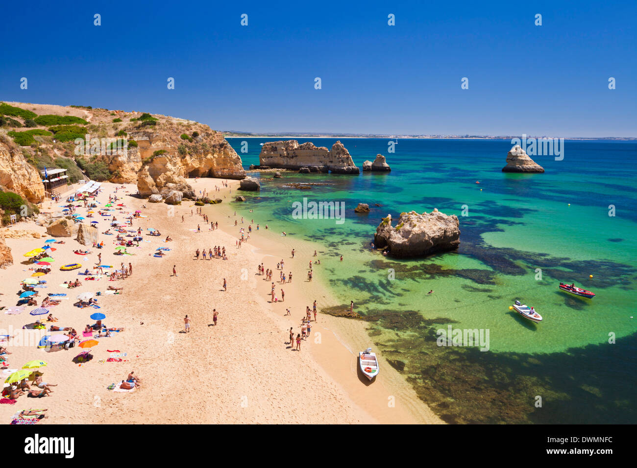 Los turistas tomando sol en Praia de Dona Ana, playa de arena, cerca de la localidad de Lagos, Algarve, Portugal, Europa Foto de stock