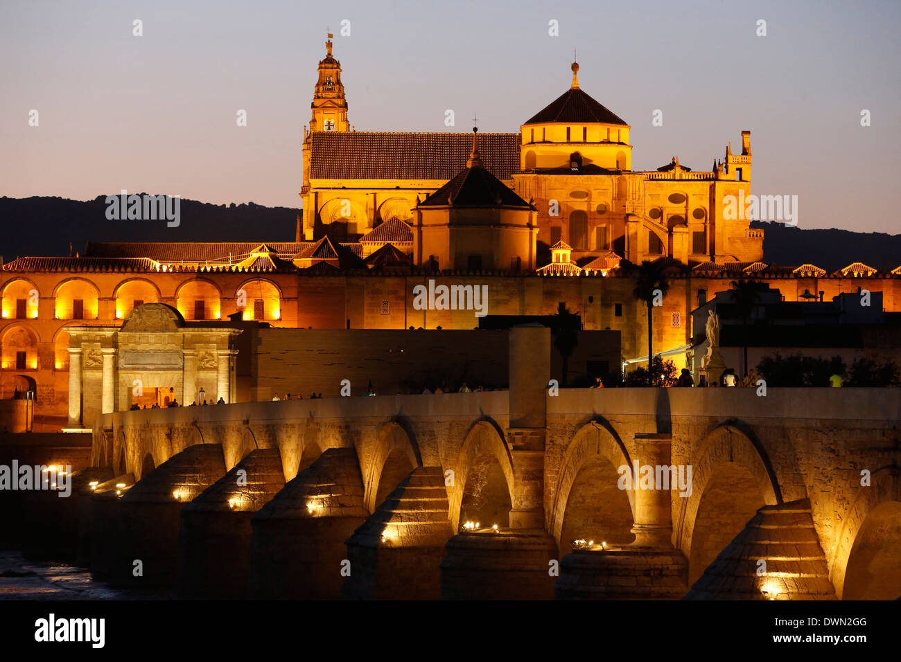 Puente romano sobre el río Guadalquivir y la Mezquita al anochecer, Sitio del Patrimonio Mundial de la UNESCO, Córdoba, Andalucía, España, Europa Foto de stock