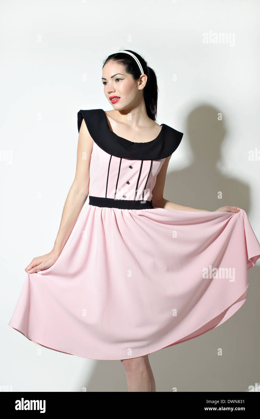 Un retro mujer vestida de un vestido vintage 50s inspirado, sosteniendo su  falda y pie elegantemente, un concepto vintage Fotografía de stock - Alamy