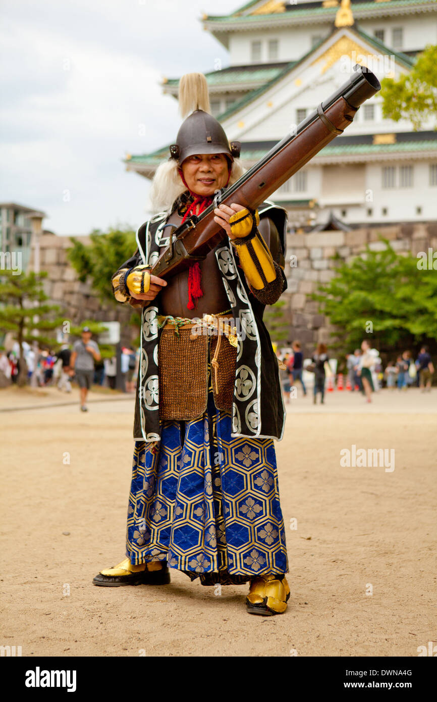 Un viejo samurai con una pistola delante del castillo de Osaka Foto de stock