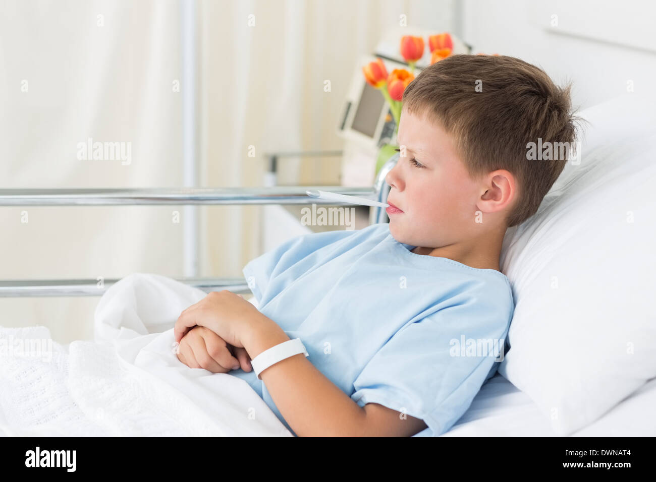 Niño en el hospital con el termómetro en la boca Foto de stock