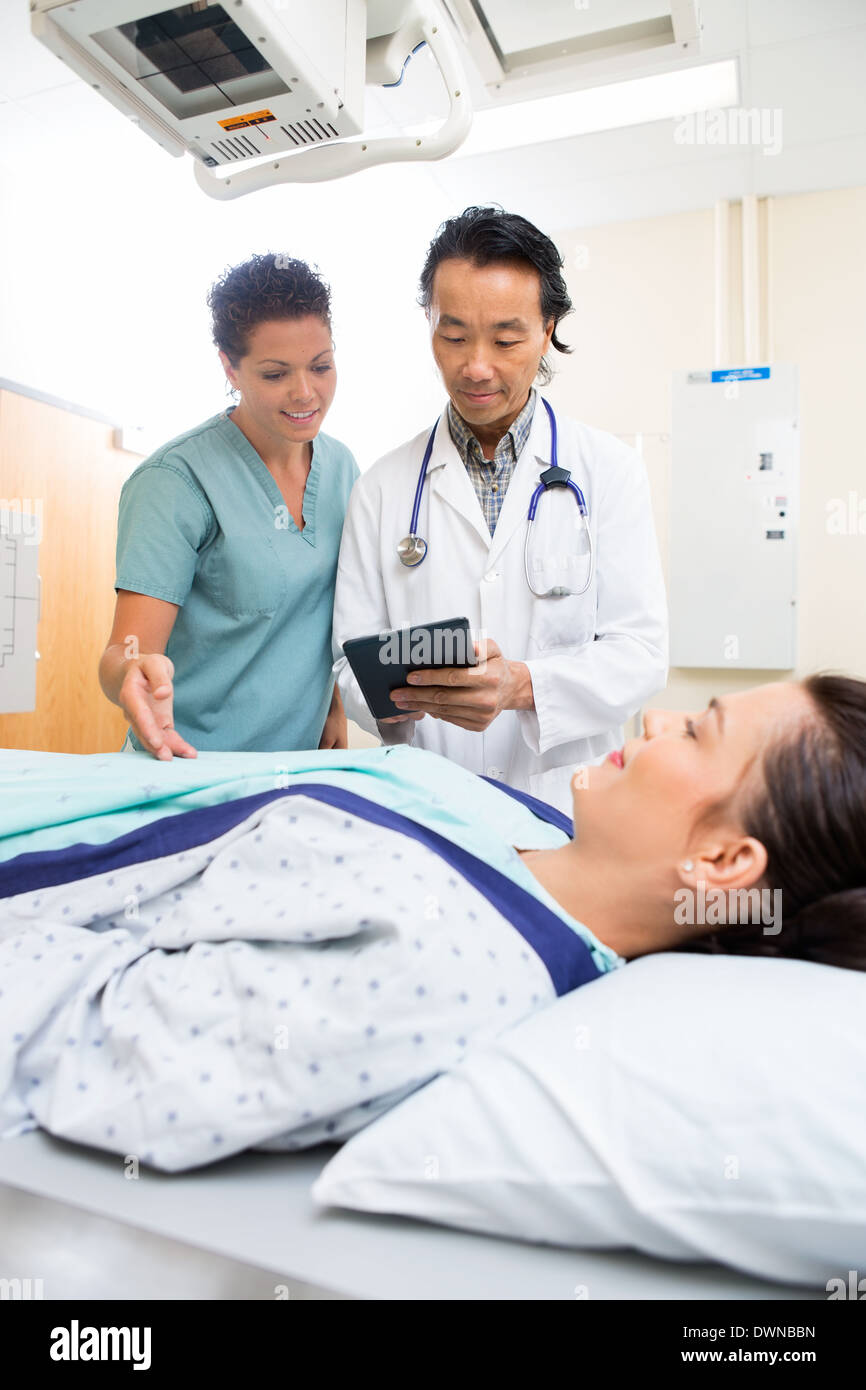 Equipo médico con tableta digital en la sala de examen Foto de stock