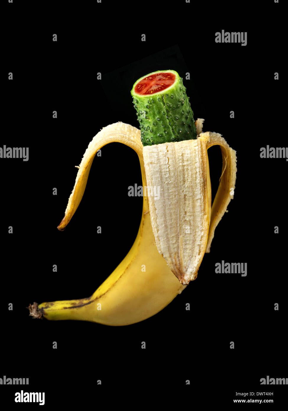 Híbrido de plátano verde, pepino y tomate como concepto OMG shot sobre negro Foto de stock