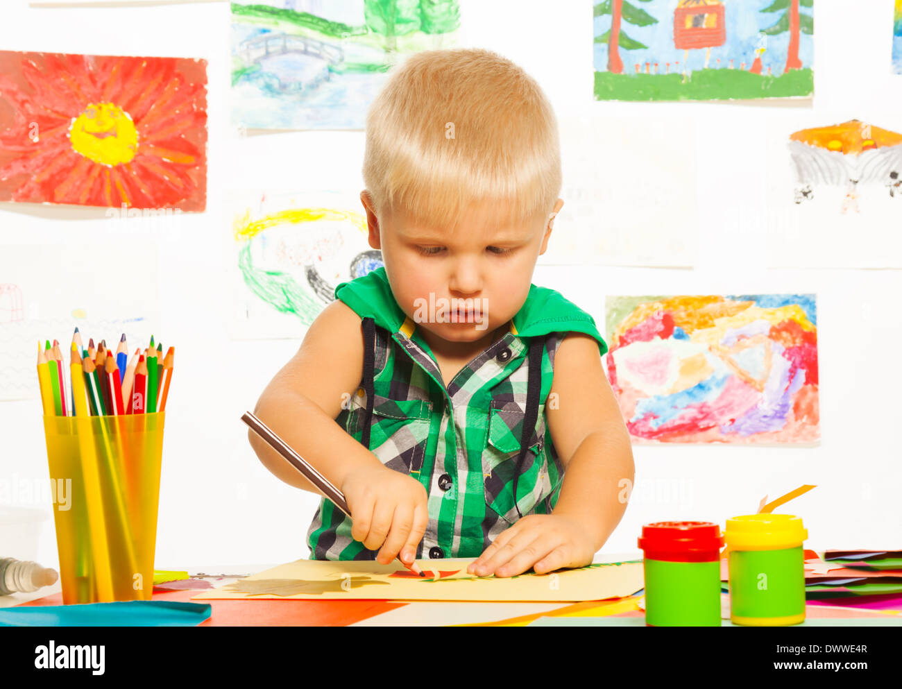 Niño de 2 años rubia dibujo con lápiz en la clase de arte de preescolar con imágenes de fondo Foto de stock