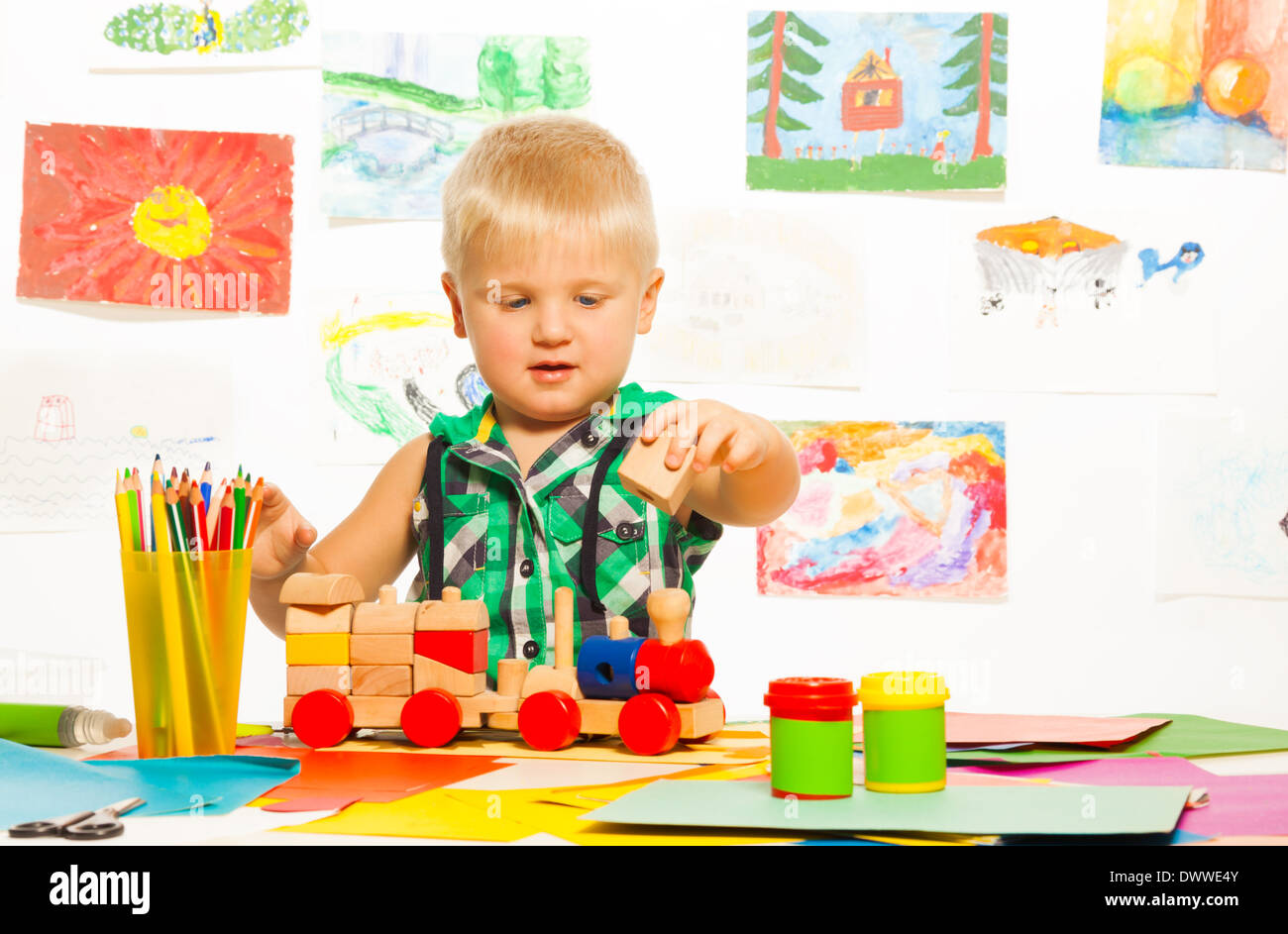 Retrato de niño de 2 años rubia en la clase de arte de preescolar con lápices de bloques y juguetes Foto de stock