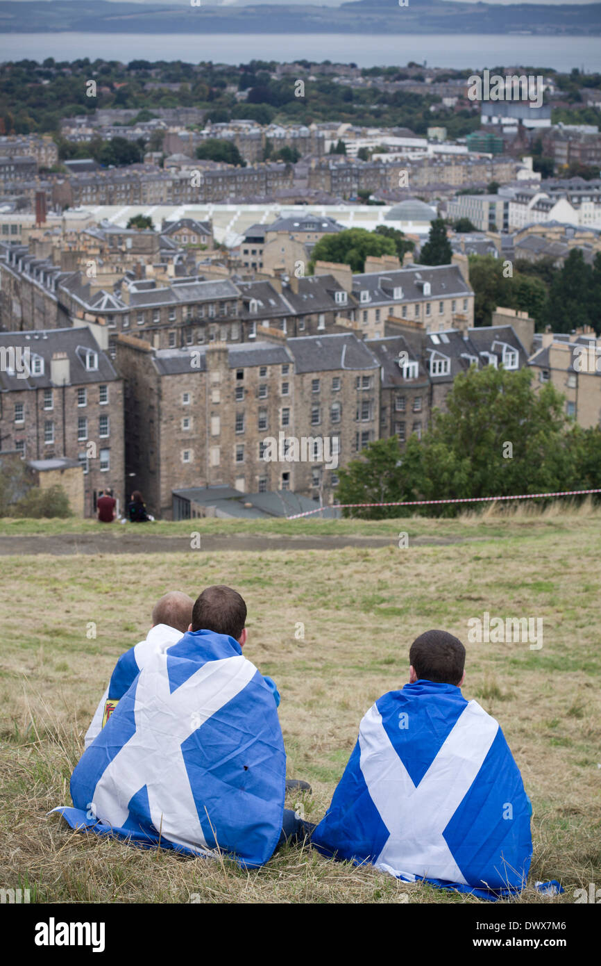 Tres jóvenes envueltos en banderas escocés sentado en Calton Hill en Edimburgo, durante un pro-independencia de marzo Foto de stock