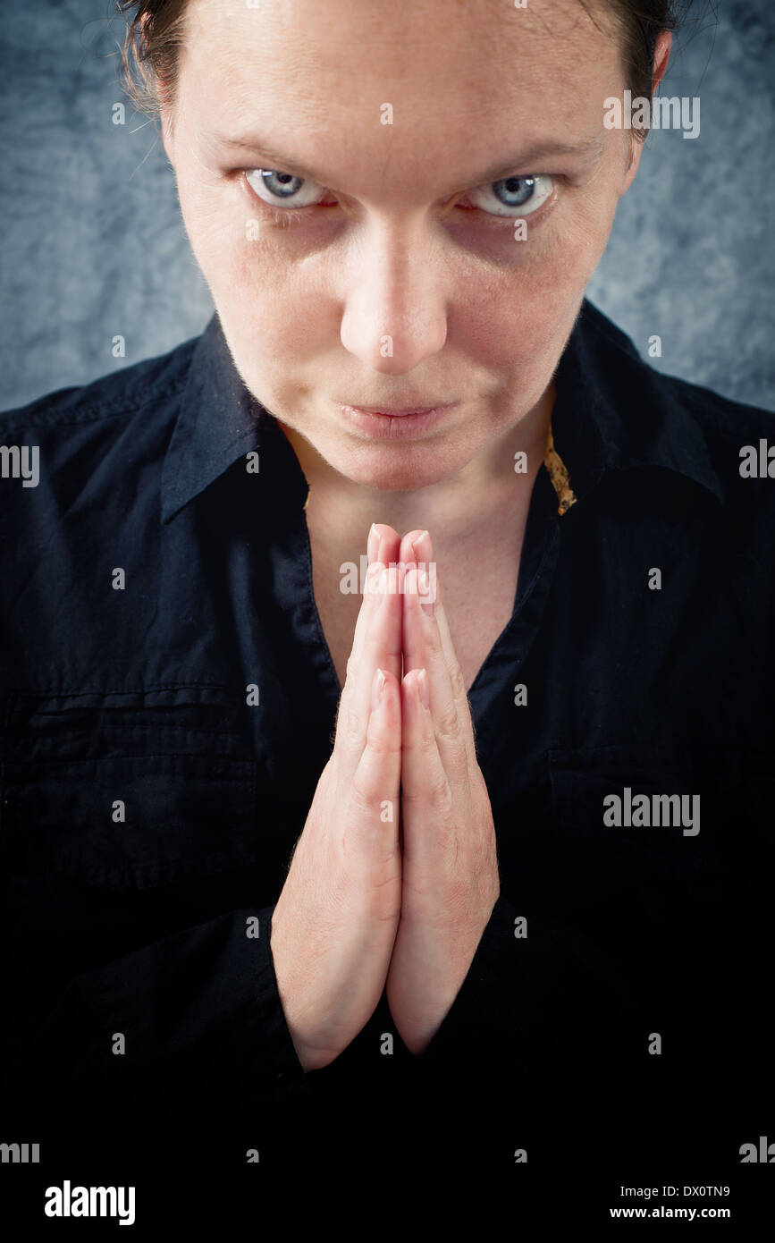 Mujer orando y alabando a Dios. La religión, la espiritualidad concepto. Foto de stock