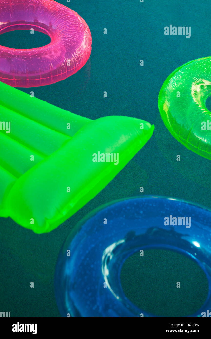 Piscinas inflables multicolores y anillos de balsa flotando en la piscina, un alto ángulo de visualización Foto de stock