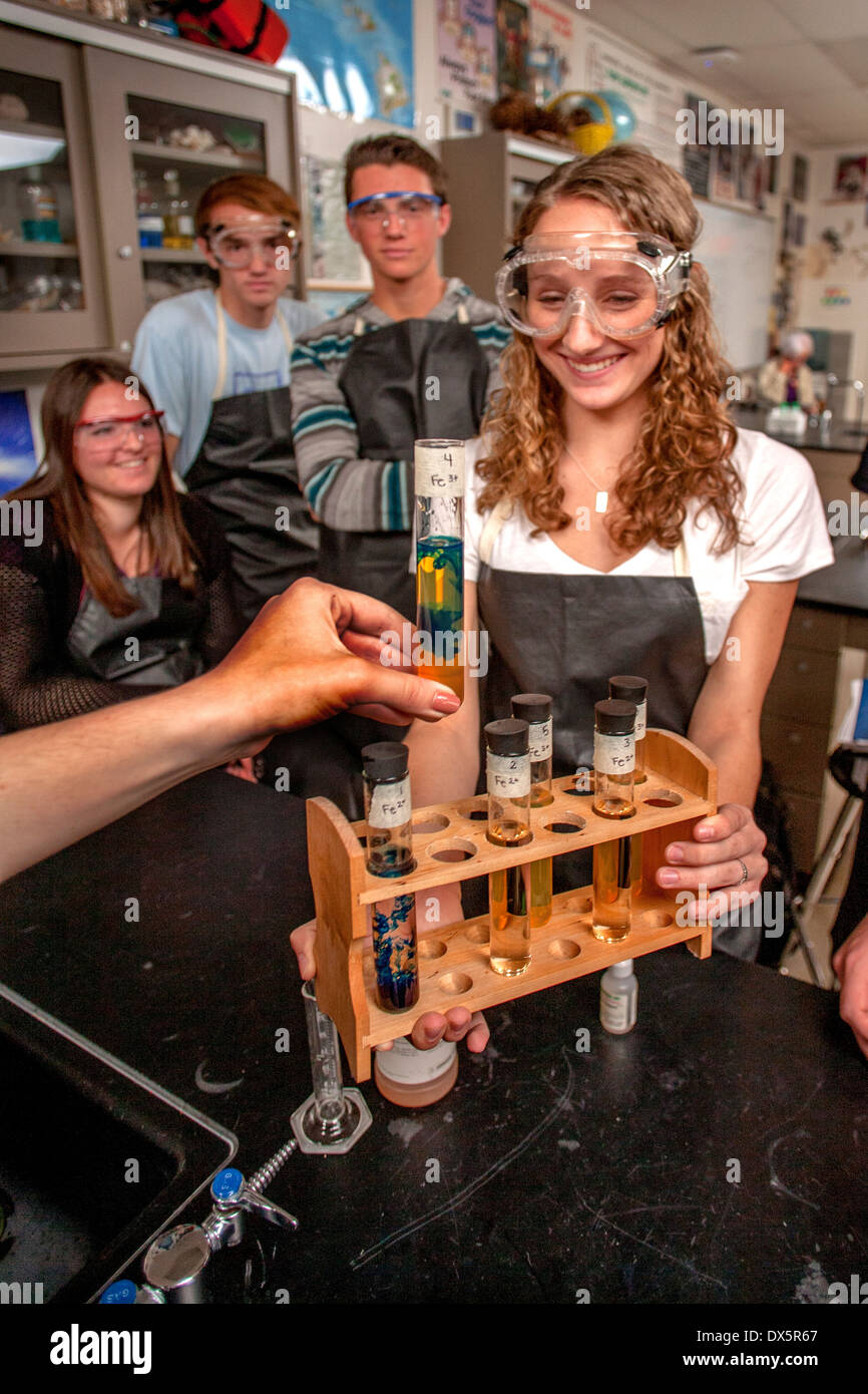 San Clemente, CA, high school los estudiantes de química demostrar reacción redox donde un precipitado azul claro indica la presencia de potasio hexacianoferrato de hierro. Nota gafas protectoras y delantales. Foto de stock