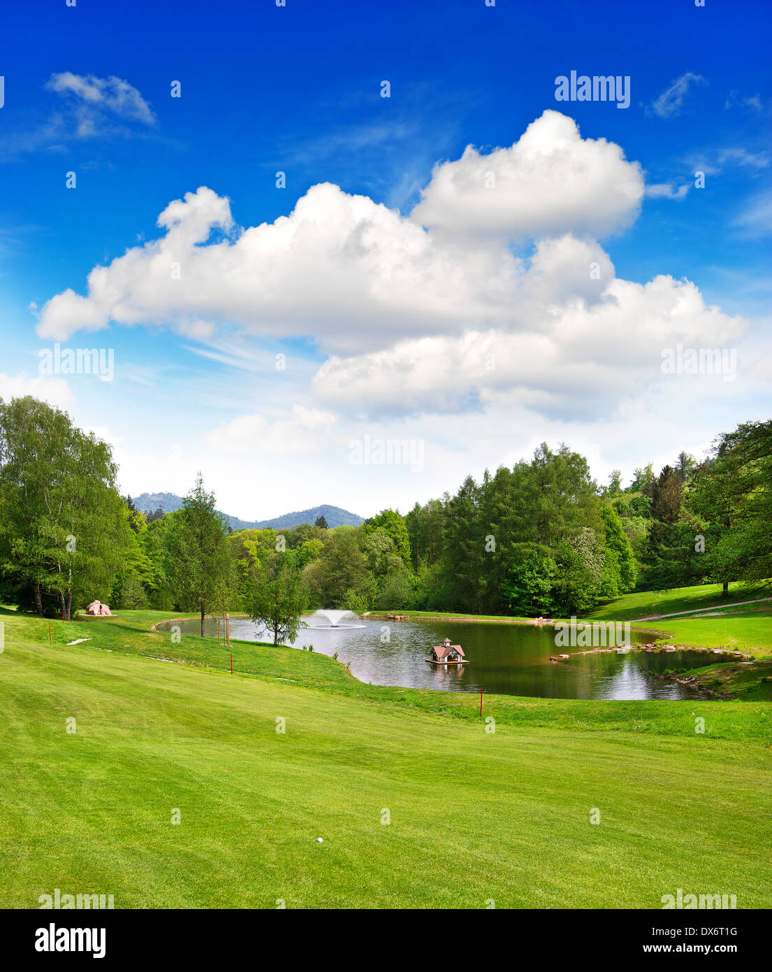 Campo de golf con el hermoso cielo azul y lago paisaje europeo. Foto de stock