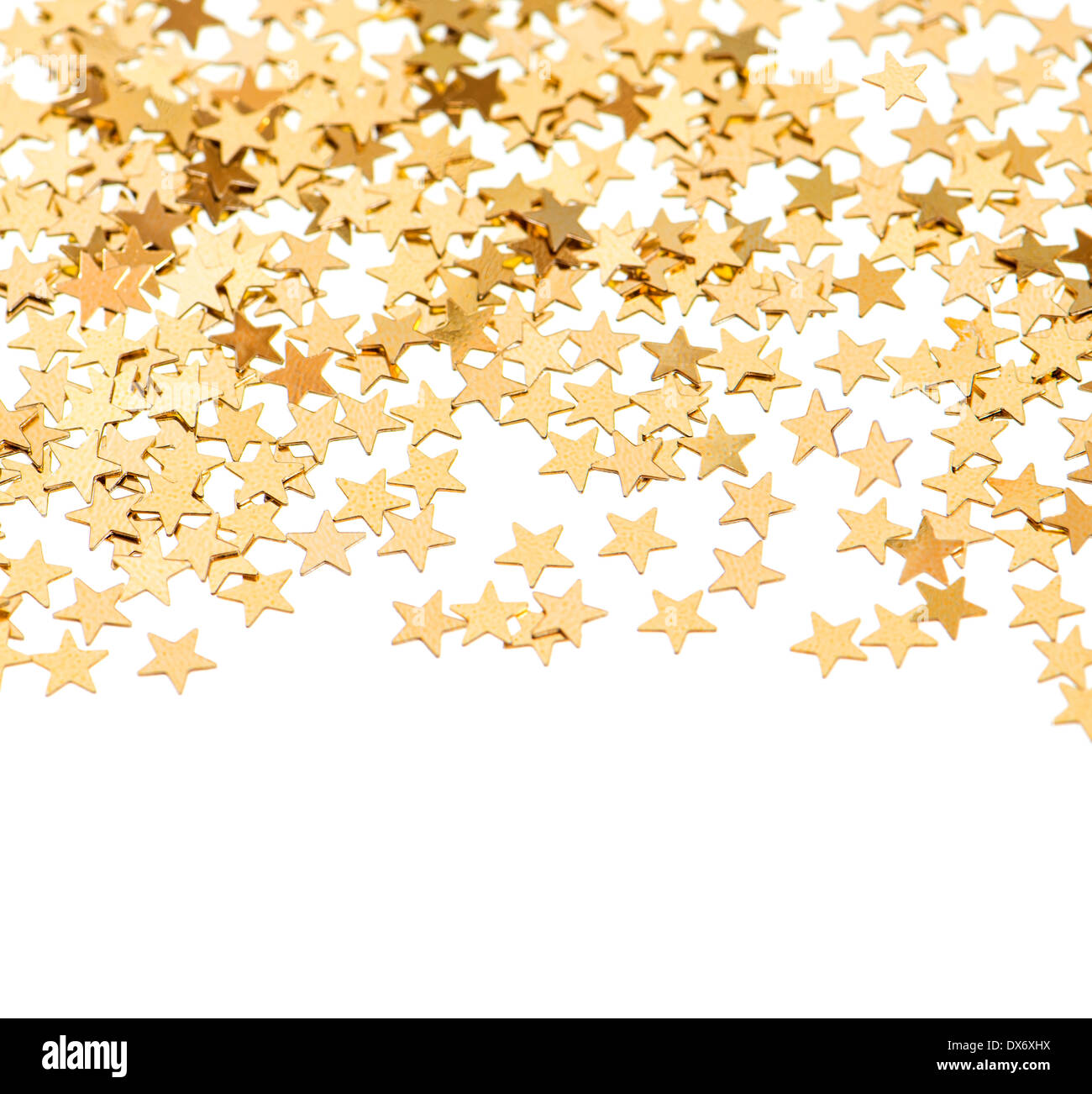 Antecedentes festiva del golden confeti en forma de estrella sobre blanco Foto de stock