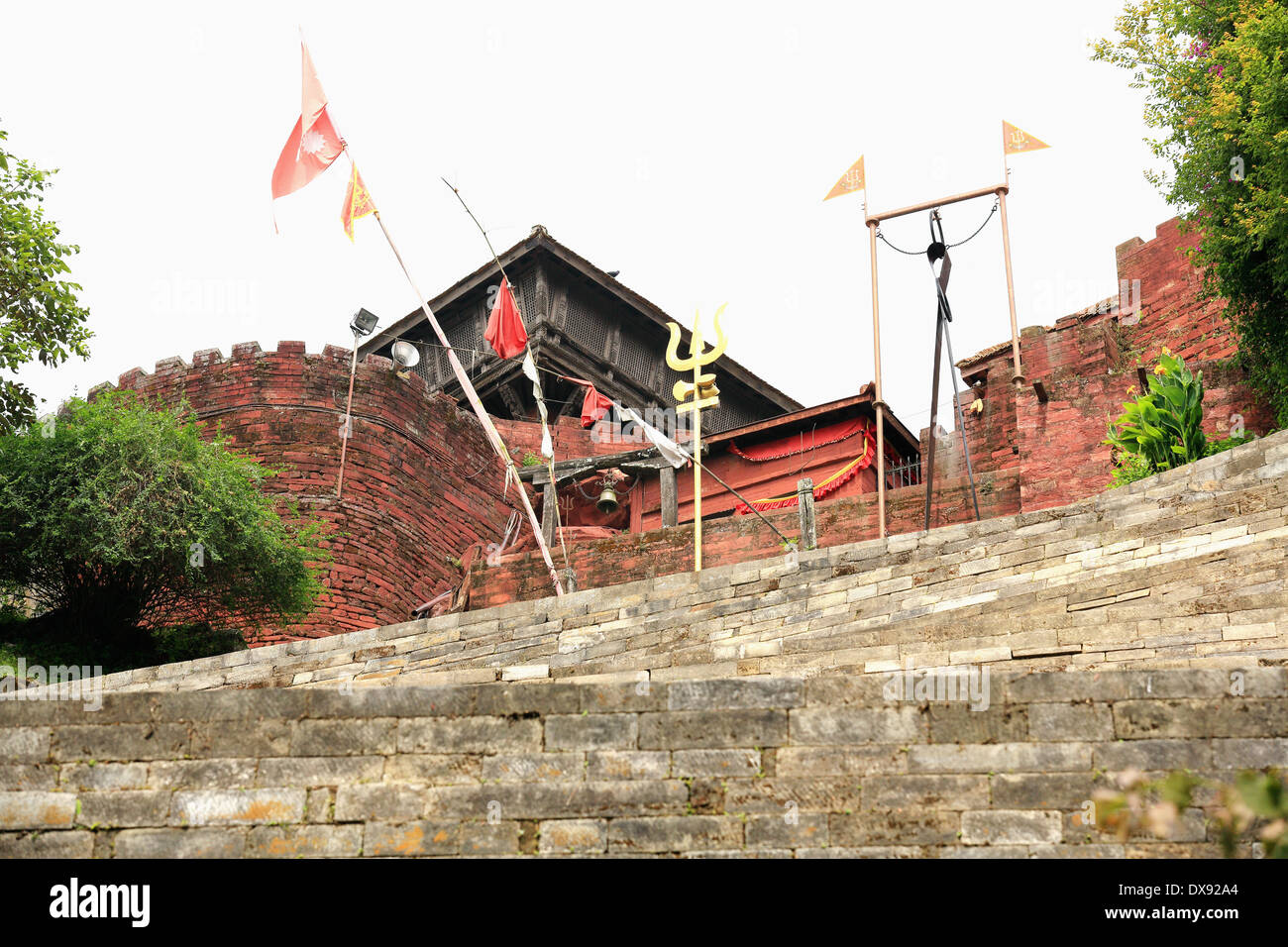 Nepali banderas y Shiva trident en la escalera que conecta el templo-cueva Gorakhnath con Gorkha Durbar. Nepal. Foto de stock