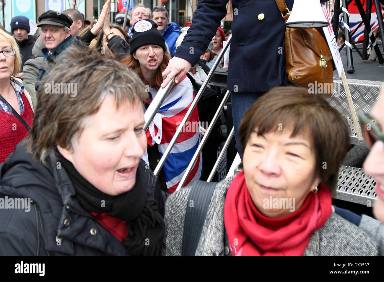 Belfast, Reino Unido, 8 de marzo de 2014. Anna Lo (derecha) de la alianza Partido en Irlanda del Norte es interpelado por un manifestante bandera leales Foto de stock