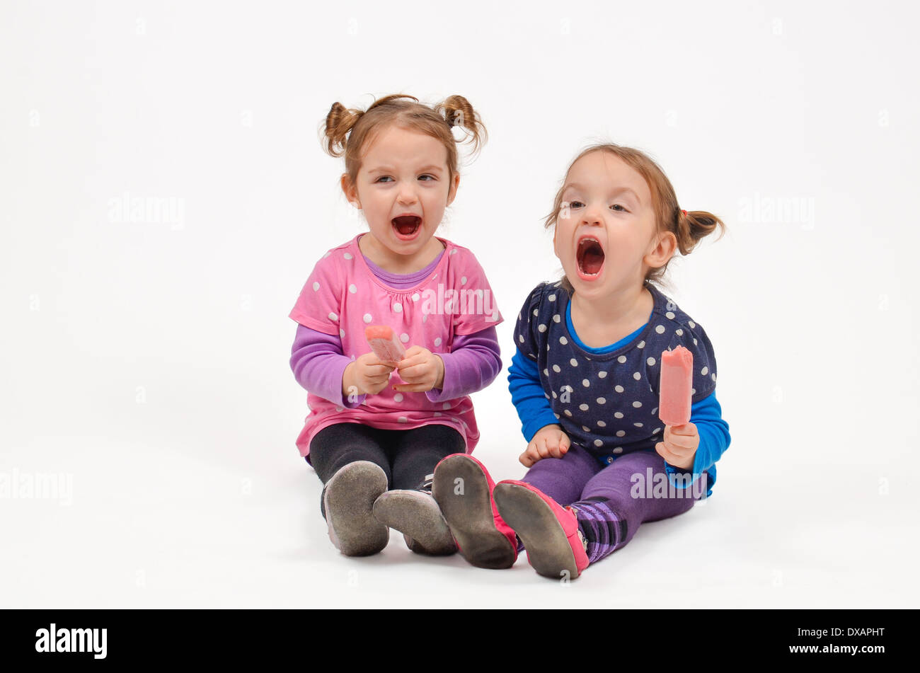 Dos niñas comer helado y gritando Foto de stock