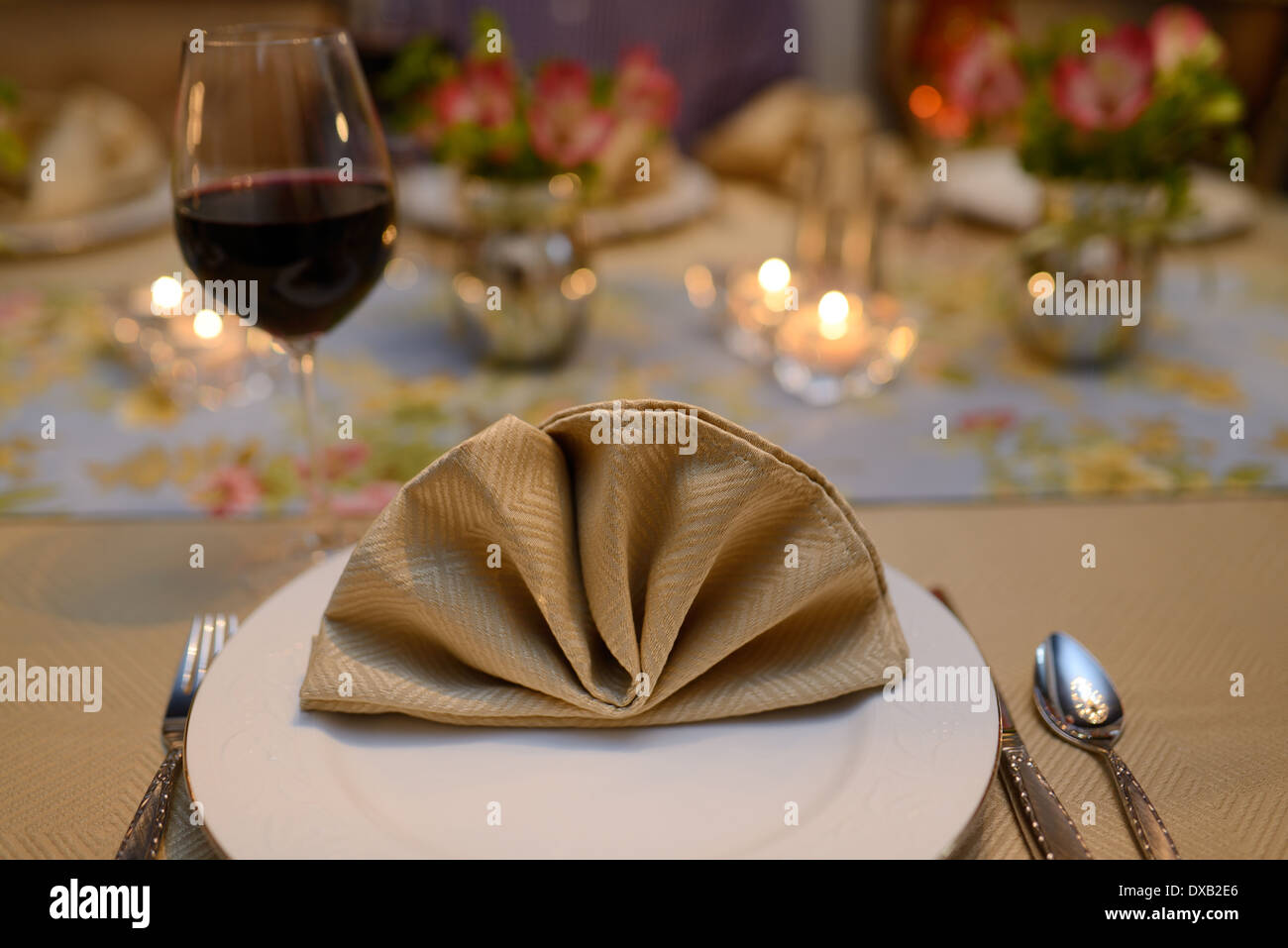 Mesa de comedor para una cena con la servilleta y vino tinto. Foto de stock
