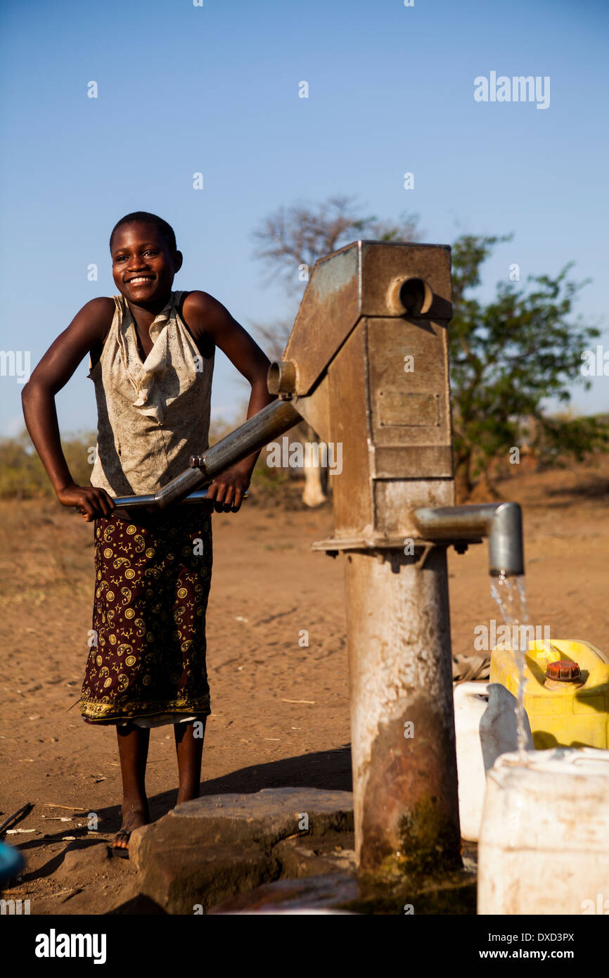 África niño recogiendo agua en un tubo de soporte Foto de stock