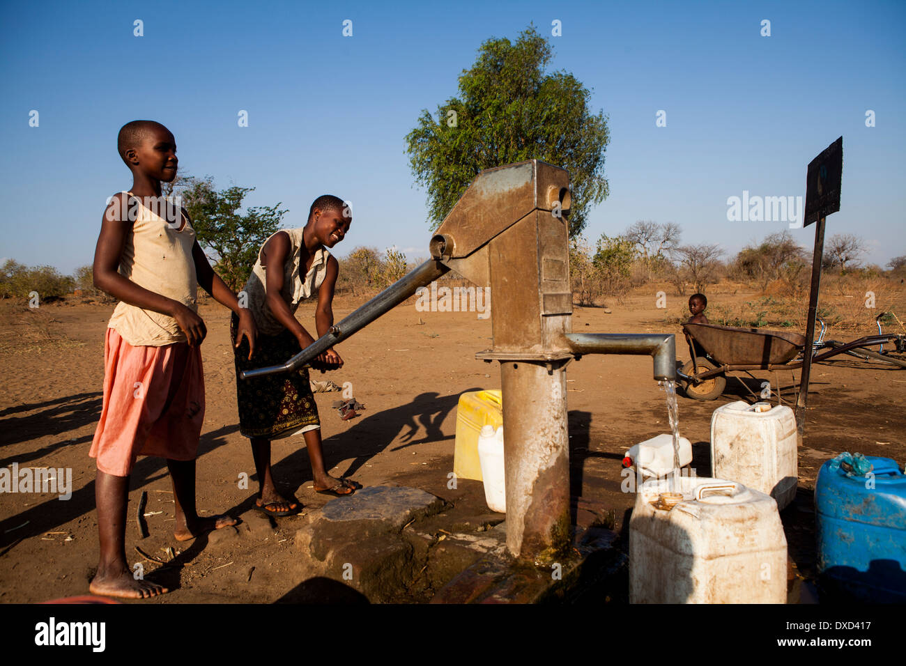 Los niños de África recogiendo agua en un tubo de soporte Foto de stock